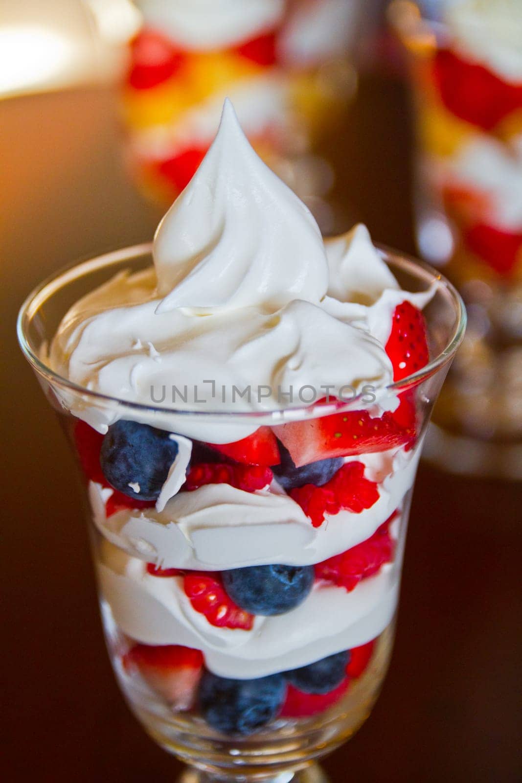 Indulge in a luscious fruit parfait with layers of fresh strawberries, blueberries, and whipped cream. A delightful treat for any occasion.