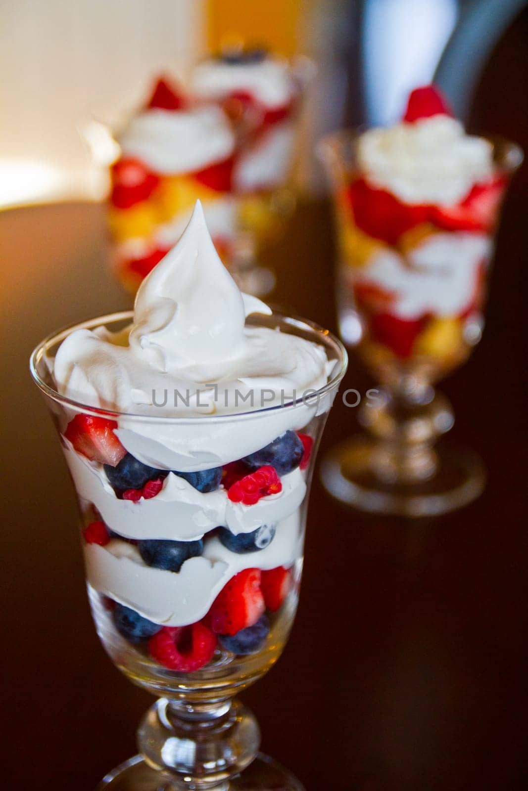 Indulge in layers of fruity bliss with this vibrant dessert featuring plump blueberries, ripe strawberries, and creamy swirls. Perfect for food and dining businesses seeking fresh and homemade appeal.