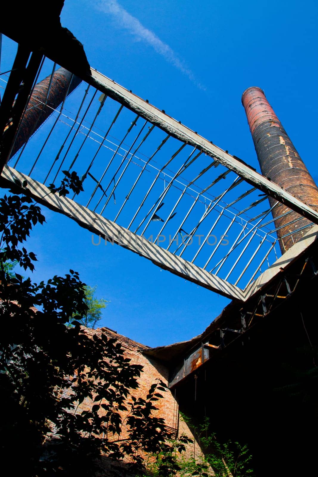 Reclaimed by Nature: Rustic Industrial Remains Under Clear Blue Sky by njproductions