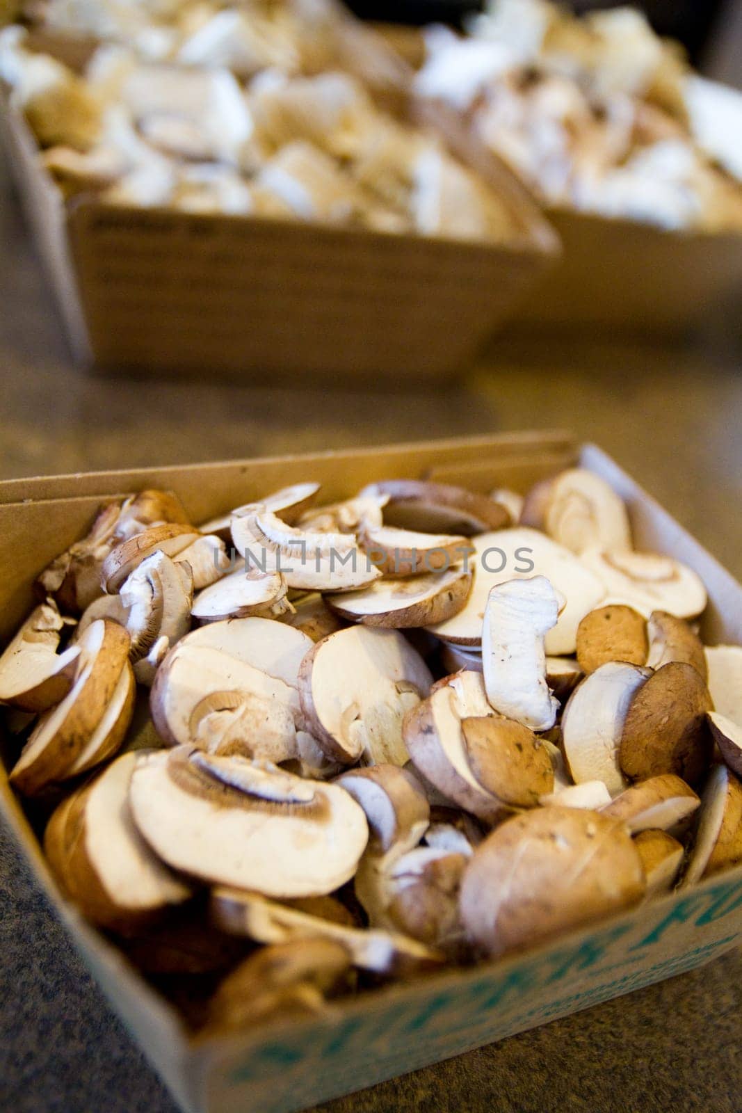 Freshly sliced mushrooms ready for cooking or sale, showcasing their creamy white to light brown hues and intricate gills. This culinary image exudes a natural, organic vibe, perfect for food industry or healthy lifestyle marketing materials.