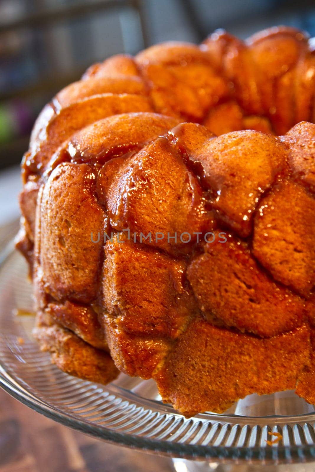 Glistening Golden Monkey Bread on Glass Stand in Cozy Kitchen Setting by njproductions