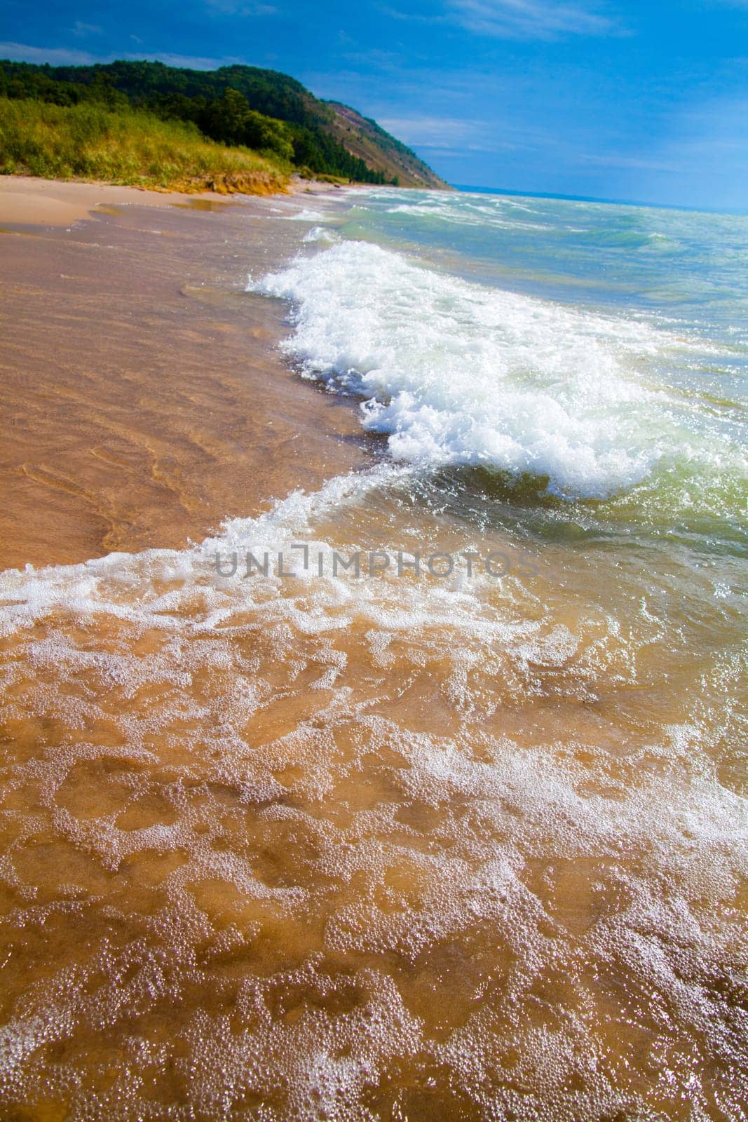 Secluded Lake Michigan Beach with Lush Greenery and Crashing Waves by njproductions