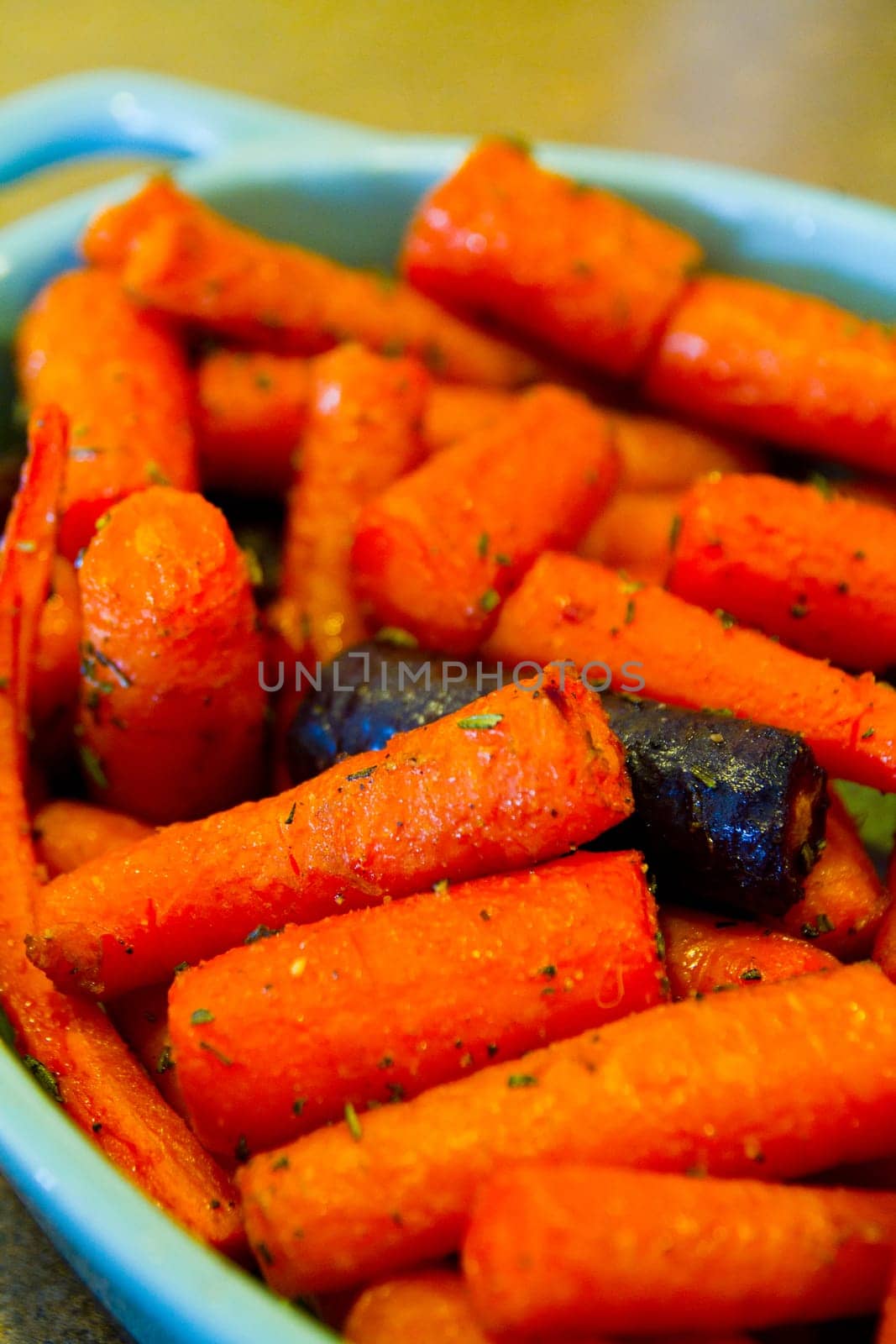 Indulge in the rich flavors of caramelized roasted carrots, served in a vibrant blue ceramic dish. A mouth-watering vegetarian delight from Fort Wayne, Indiana.