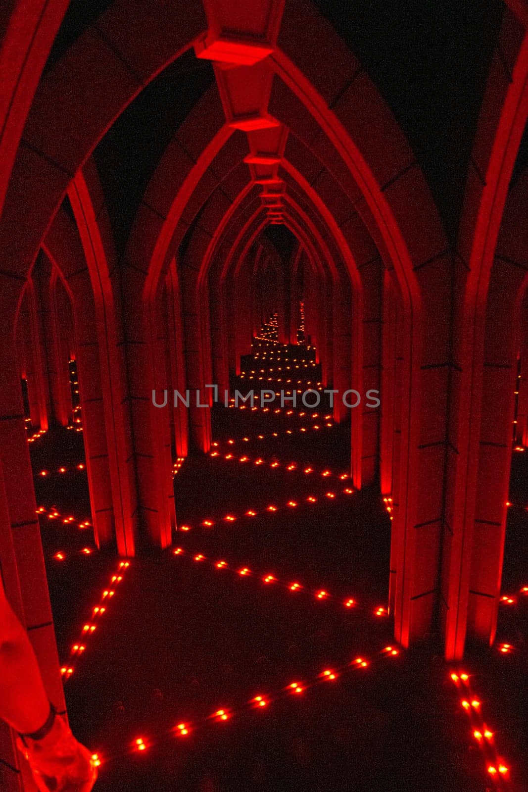 Enigmatic Mirror Maze bathed in a monochromatic red hue create a suspenseful atmosphere in an architectural structure resembling a cathedral aisle. Perfect for horror, thrillers, historical themes, or marketing materials.