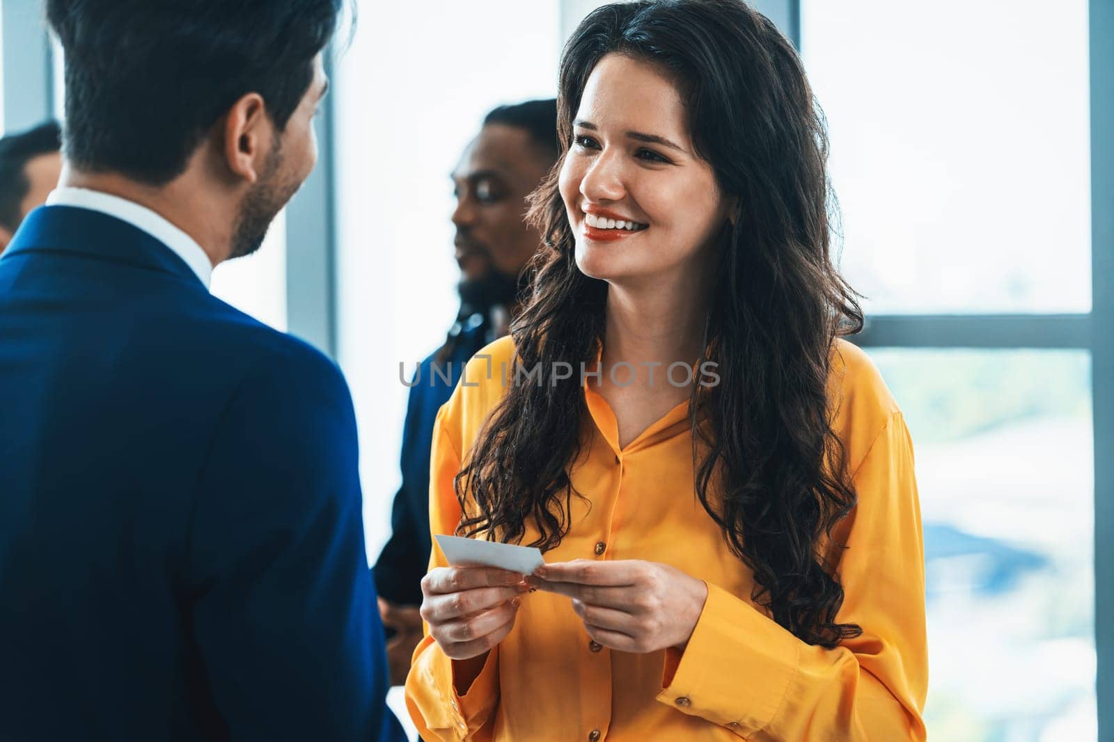 Successful businesswoman holding the name card during talking to manager about their cooperation. Female leader looking businessman during hold his name card admirably. Intellectual.