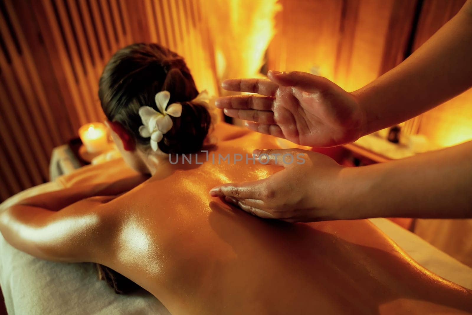 Caucasian woman customer enjoying relaxing anti-stress spa massage and pampering with beauty skin recreation leisure in warm candle lighting ambient salon spa at luxury resort or hotel. Quiescent