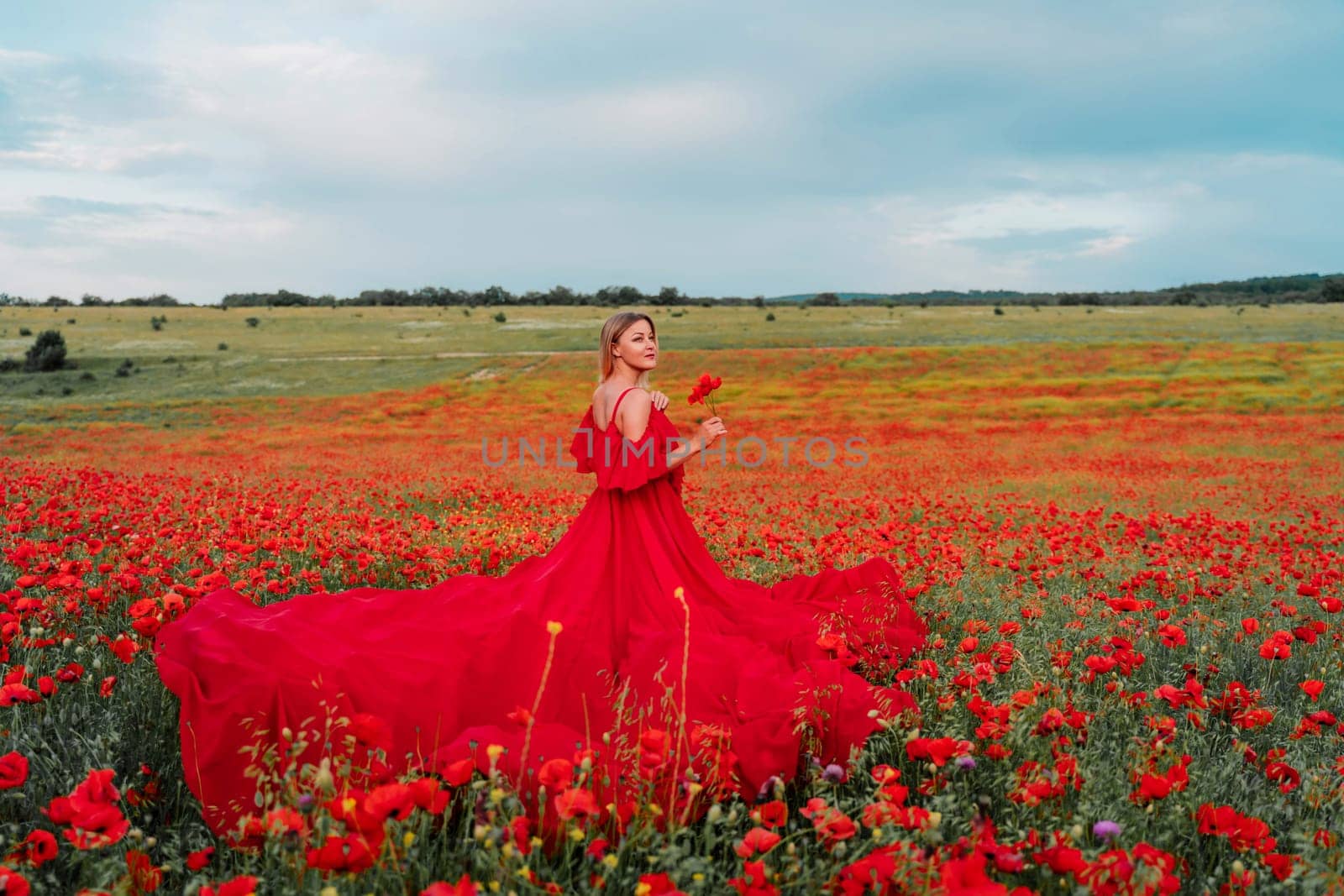 Woman poppy field red dress. Happy woman in a long red dress in a beautiful large poppy field. Blond stands with her back posing on a large field of red poppies by Matiunina