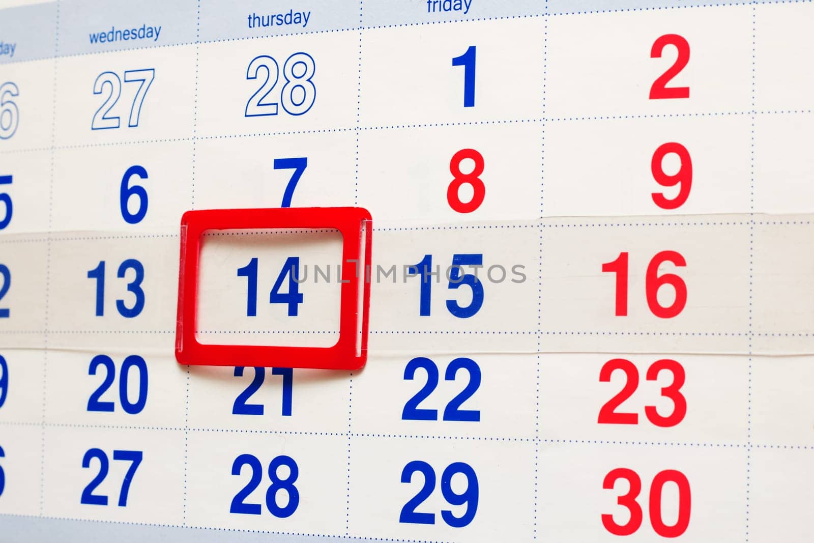 White calendar with a marked date fourteenth, close up