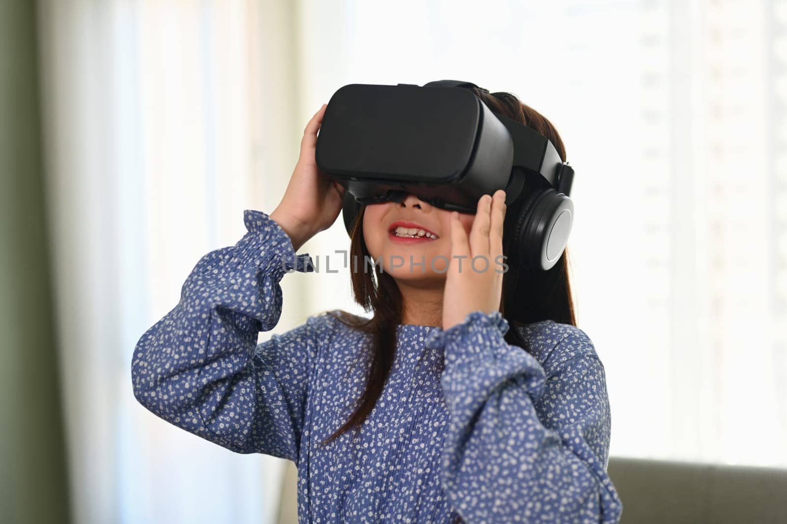 Happy schoolgirl using VR glasses for education learning. Future education technology concept