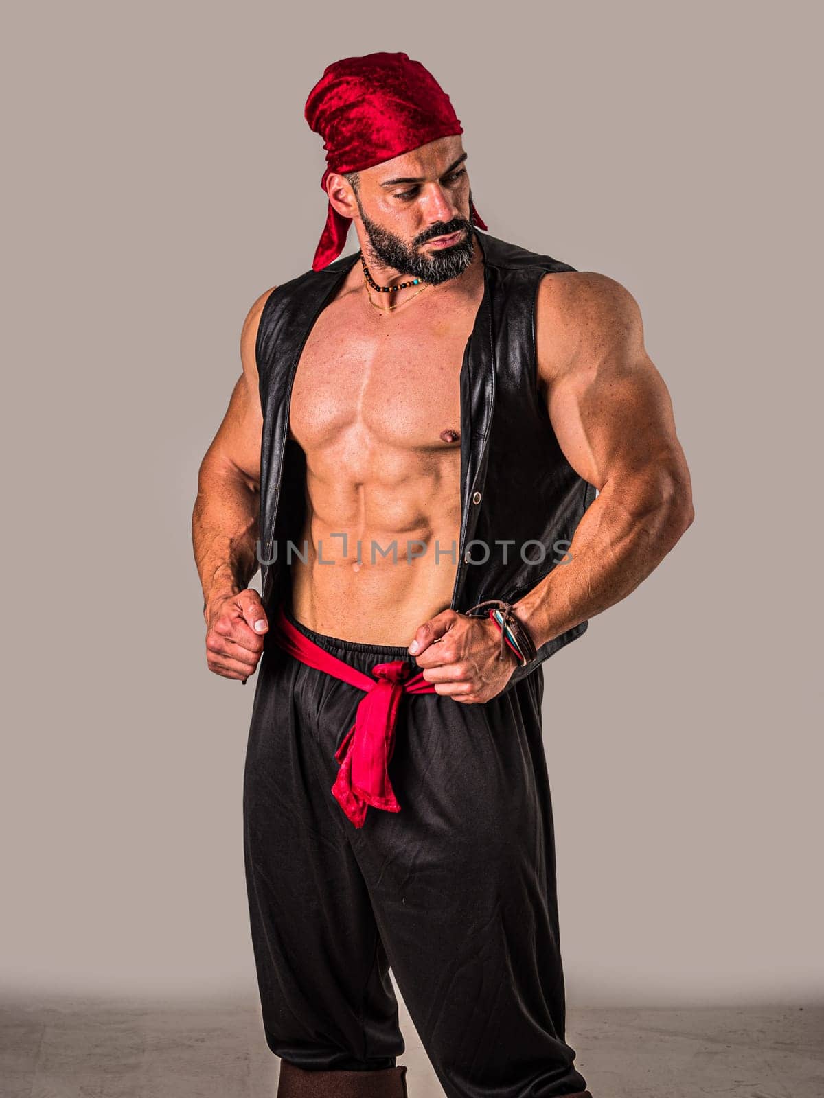 A muscular topless man with a red bandanna and pirate costume, standing in front of a white background. A Brave Soul in Crimson: A Male Bodybuilder with a Red Bandanna Standing Proudly Before a Clean Canvas