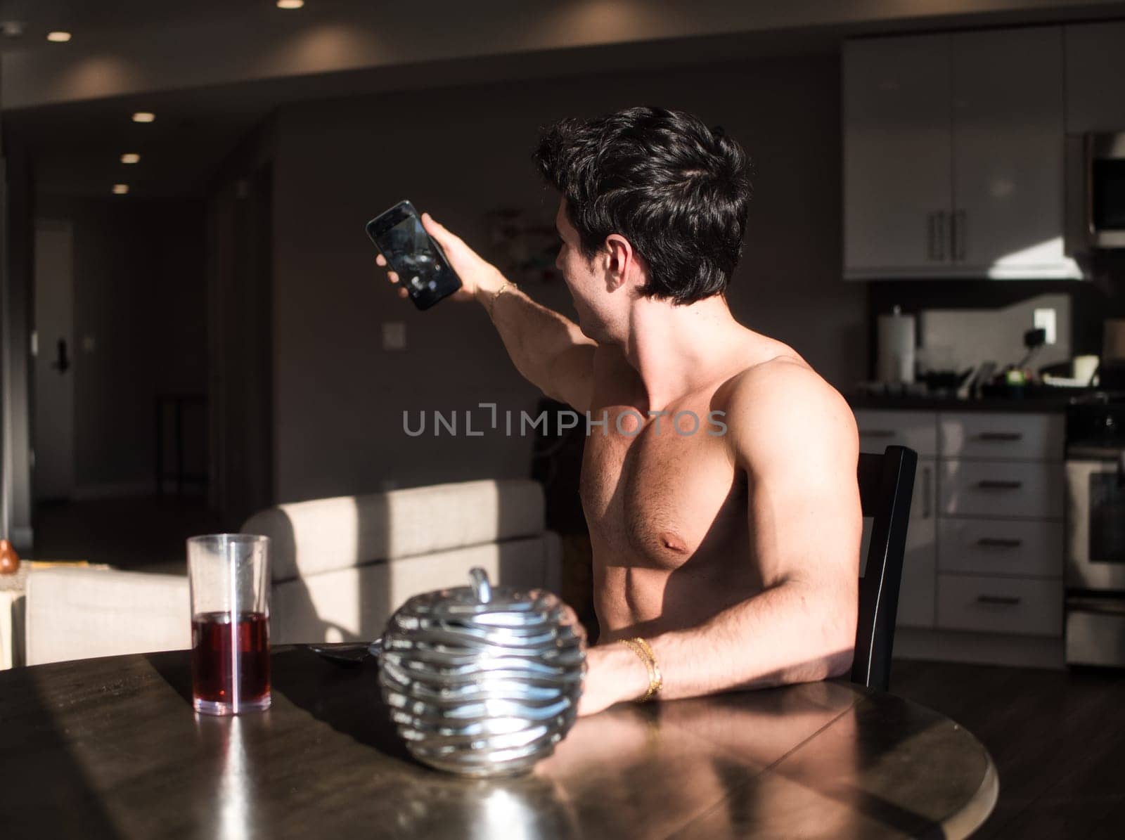 Photo of a man capturing a self-portrait at a table in the morning light by artofphoto