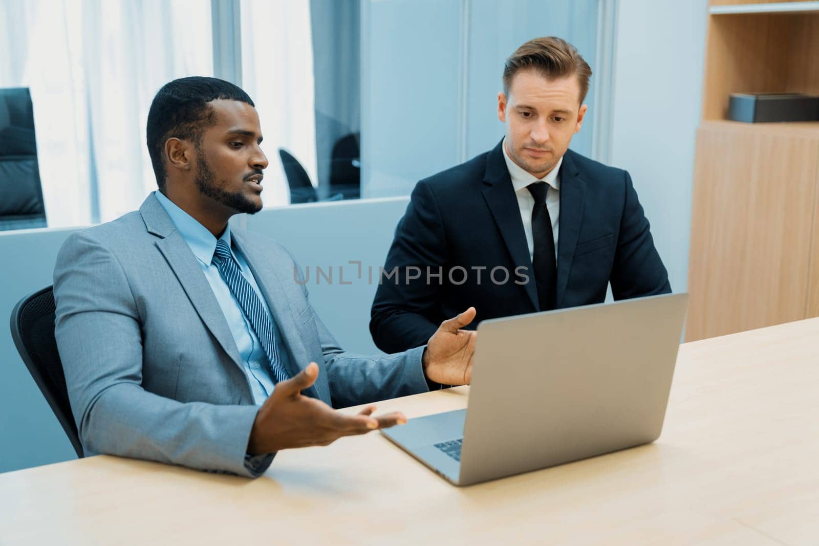 Cooperative handsome african businessman present start up project while manager listen and decide to invest. Two businesspeople making agreement, reporting data. Multicultural business. Ornamented.