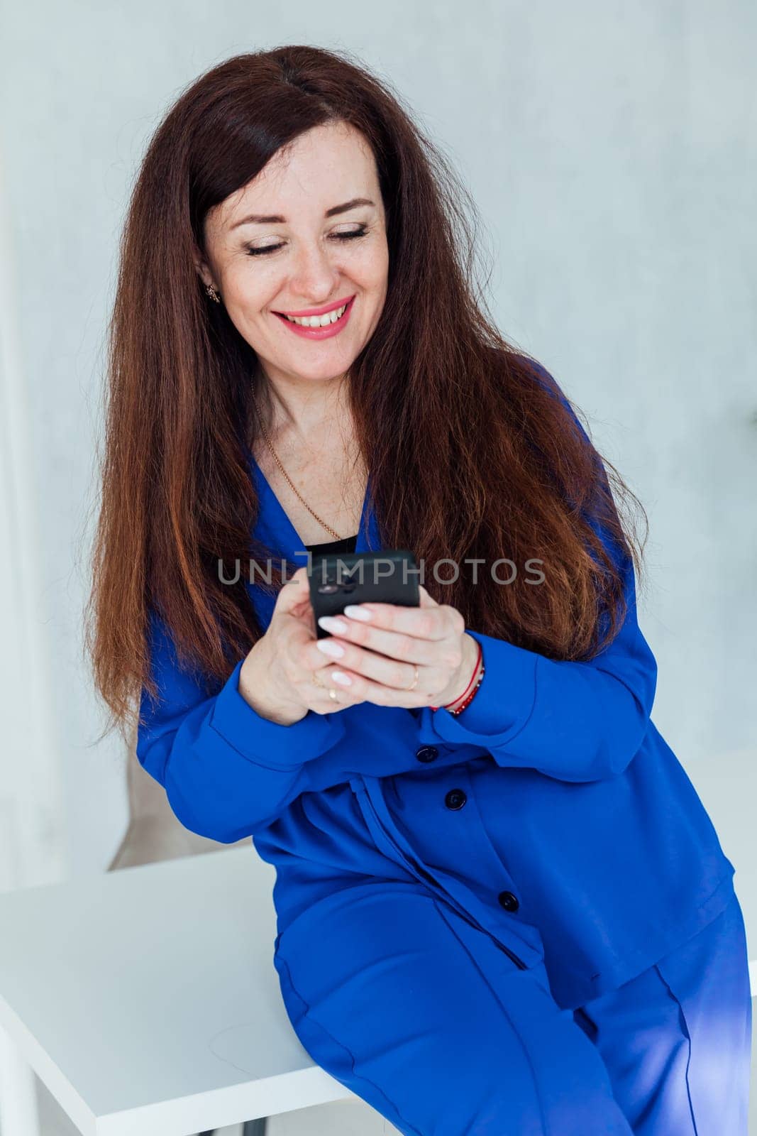 brunette woman negotiating on smartphone business online in office