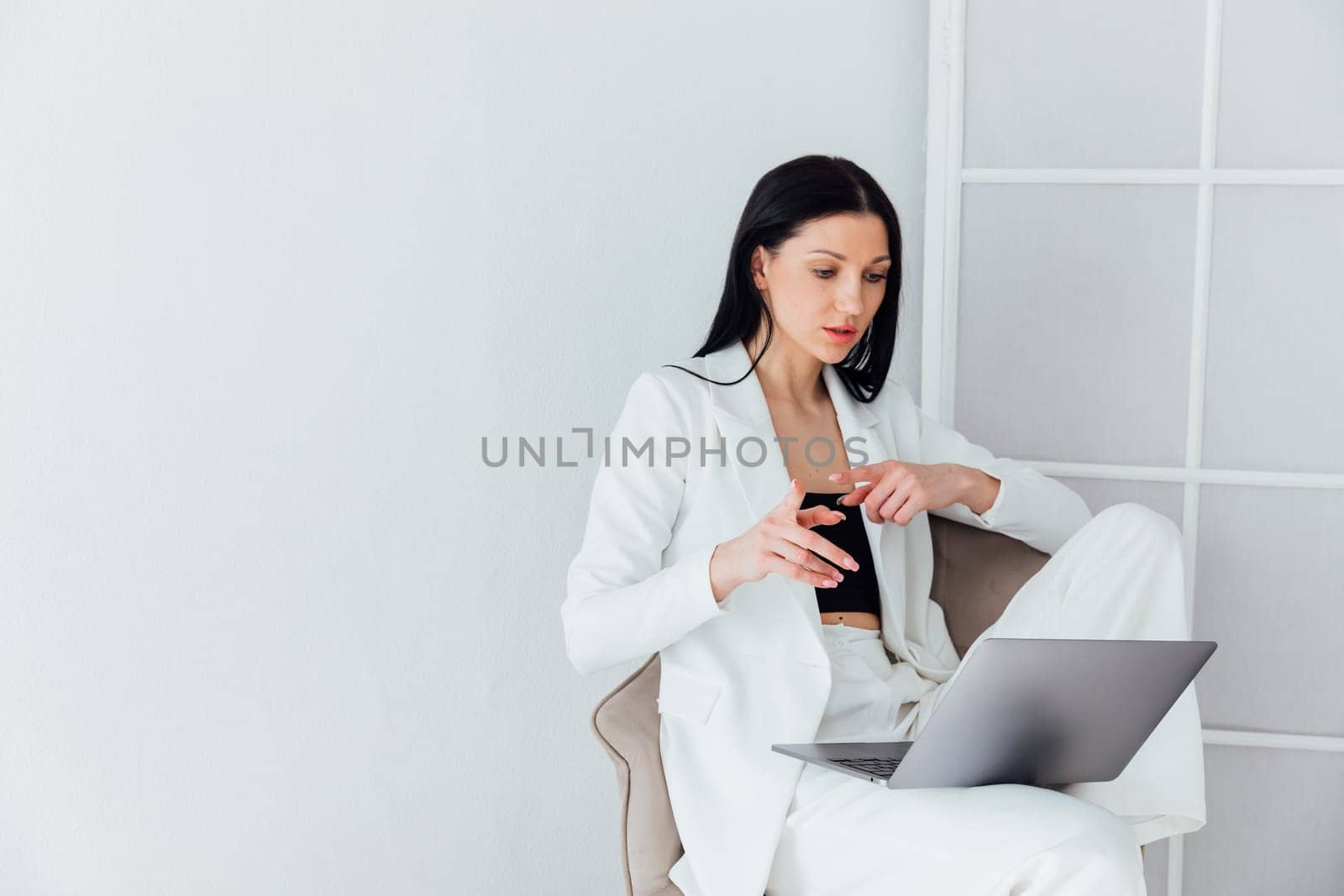 woman in white suit working on laptop small business online