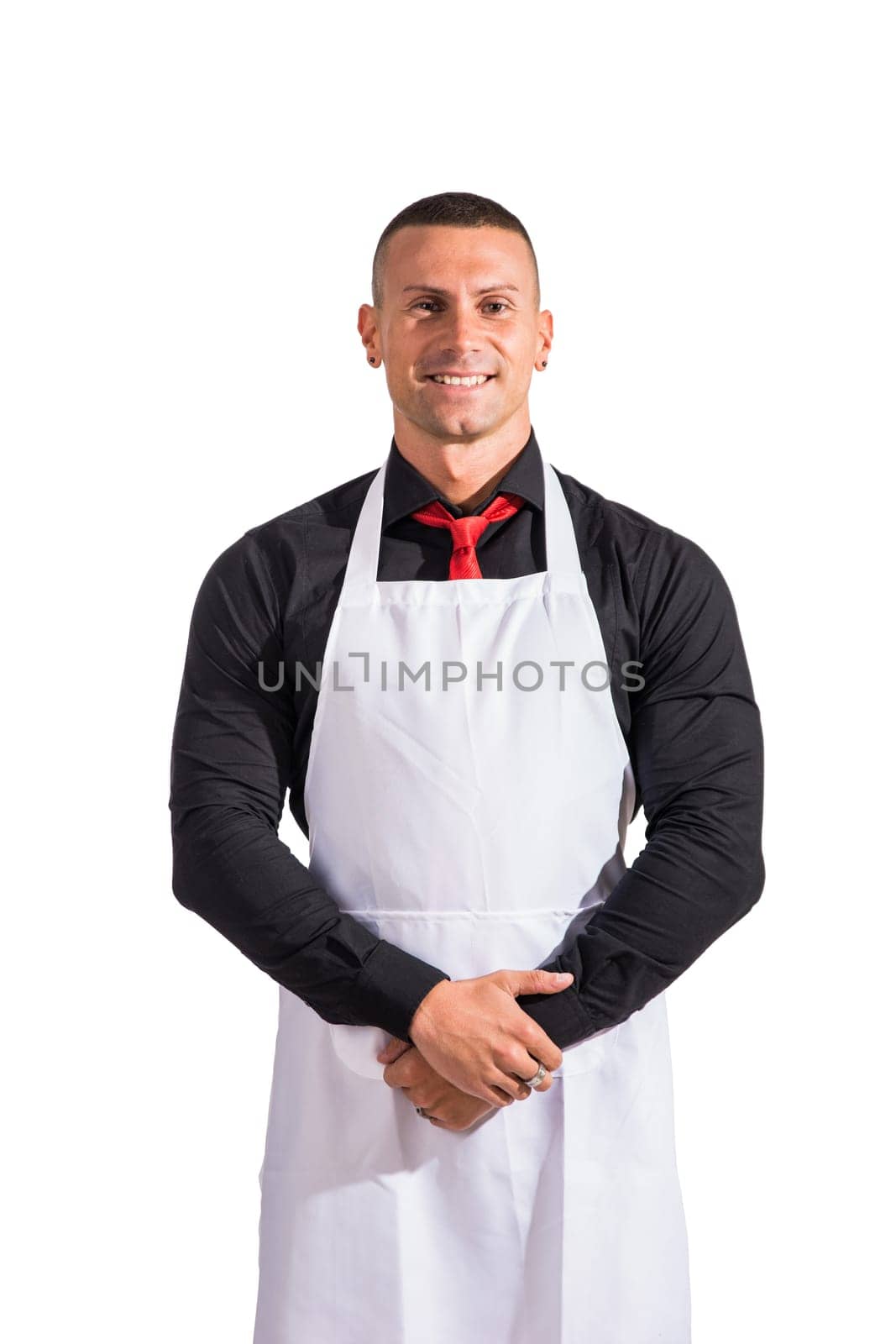 Attractive chef or waiter posing, wearing white apron and black shirt isolated on white background, in studio shot