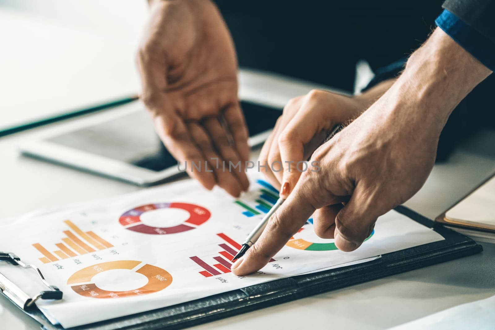 Businessman and businesswoman in meeting working with many financial statement document on desk. Concept of busy business profit analysis and brainstorm. Close up shot at people hands and papers. uds