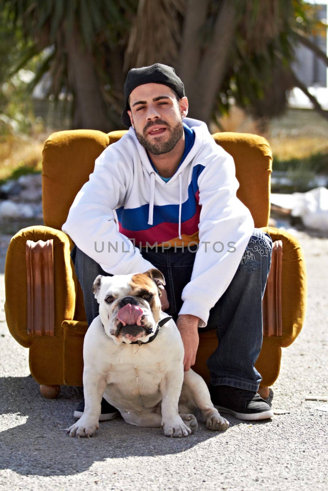Couch, city and portrait of man with dog in street for urban fashion, casual style and trendy outfit. Hip hop, pets and person on sofa in road with canine, bulldog and best friend for relaxing by YuriArcurs
