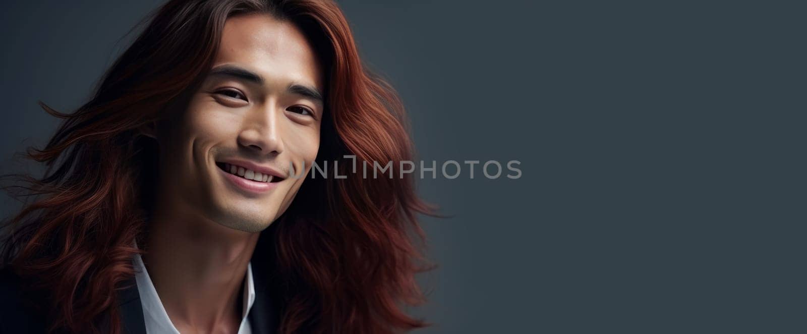 Handsome young male guy smile Asian with long red hair, on gray background, banner, copy space, portrait. by Alla_Yurtayeva
