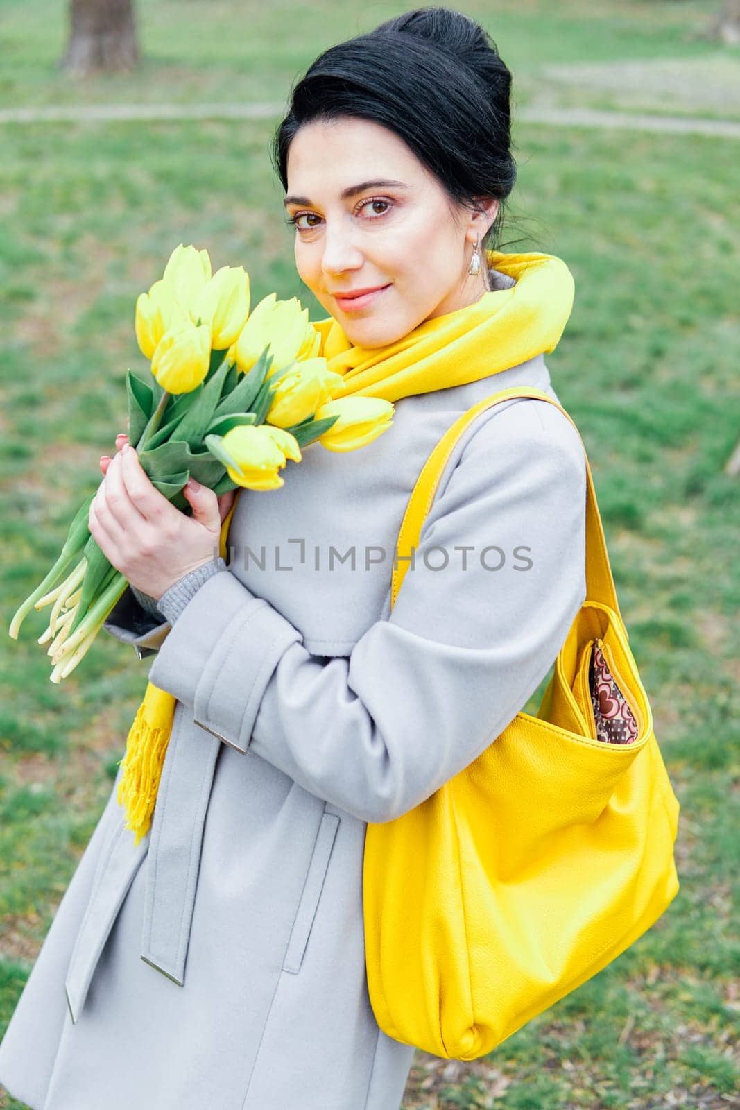 Portrait of brunette in coats with yellow tulips by Simakov