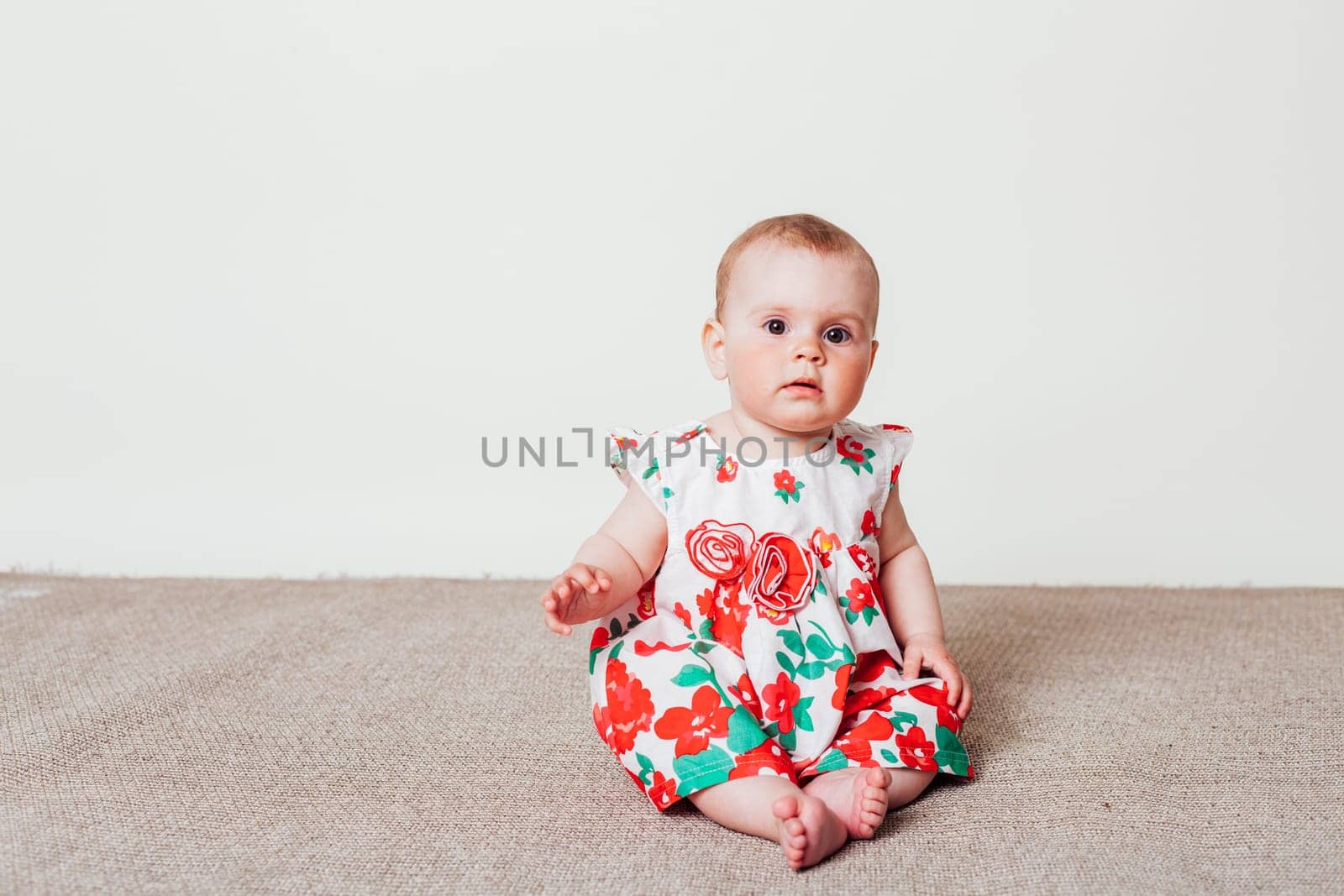 baby girl in a dress with red flowers by Simakov