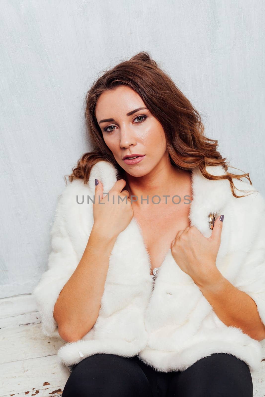 portrait of a beautiful fashionable woman with curls in a fur coat by Simakov