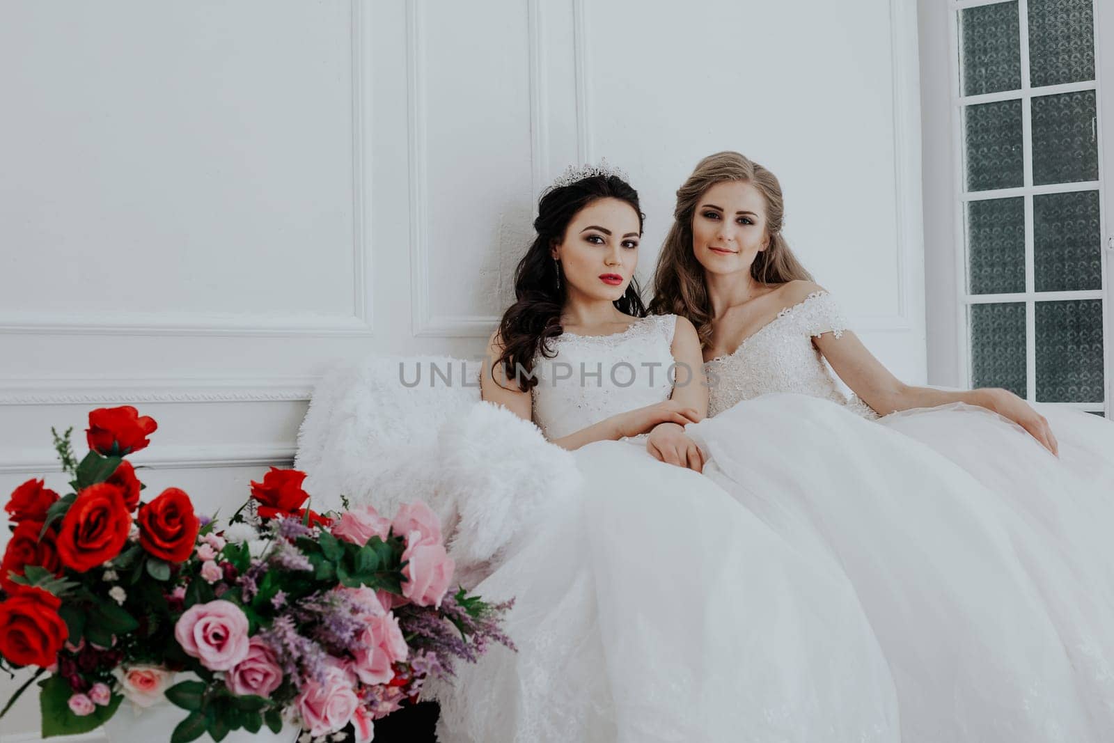 Portrait of two young women in wedding dresses in White Hall by Simakov