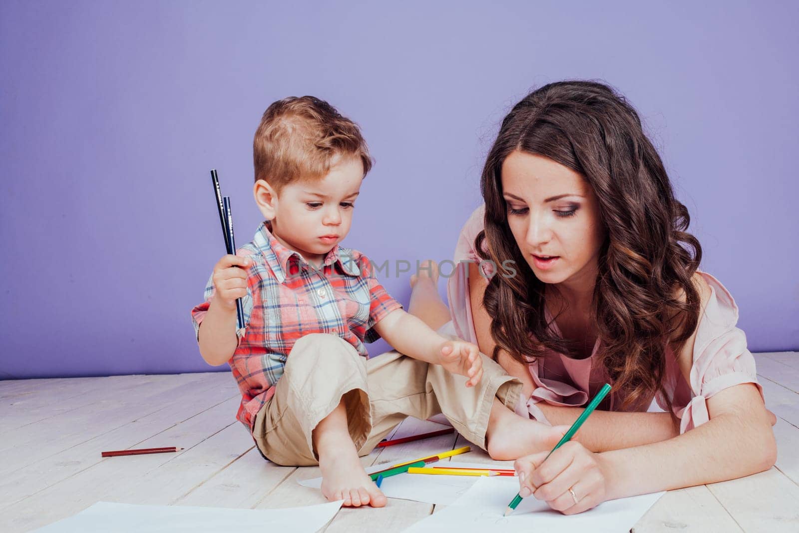 mother and young son play paint color crayons