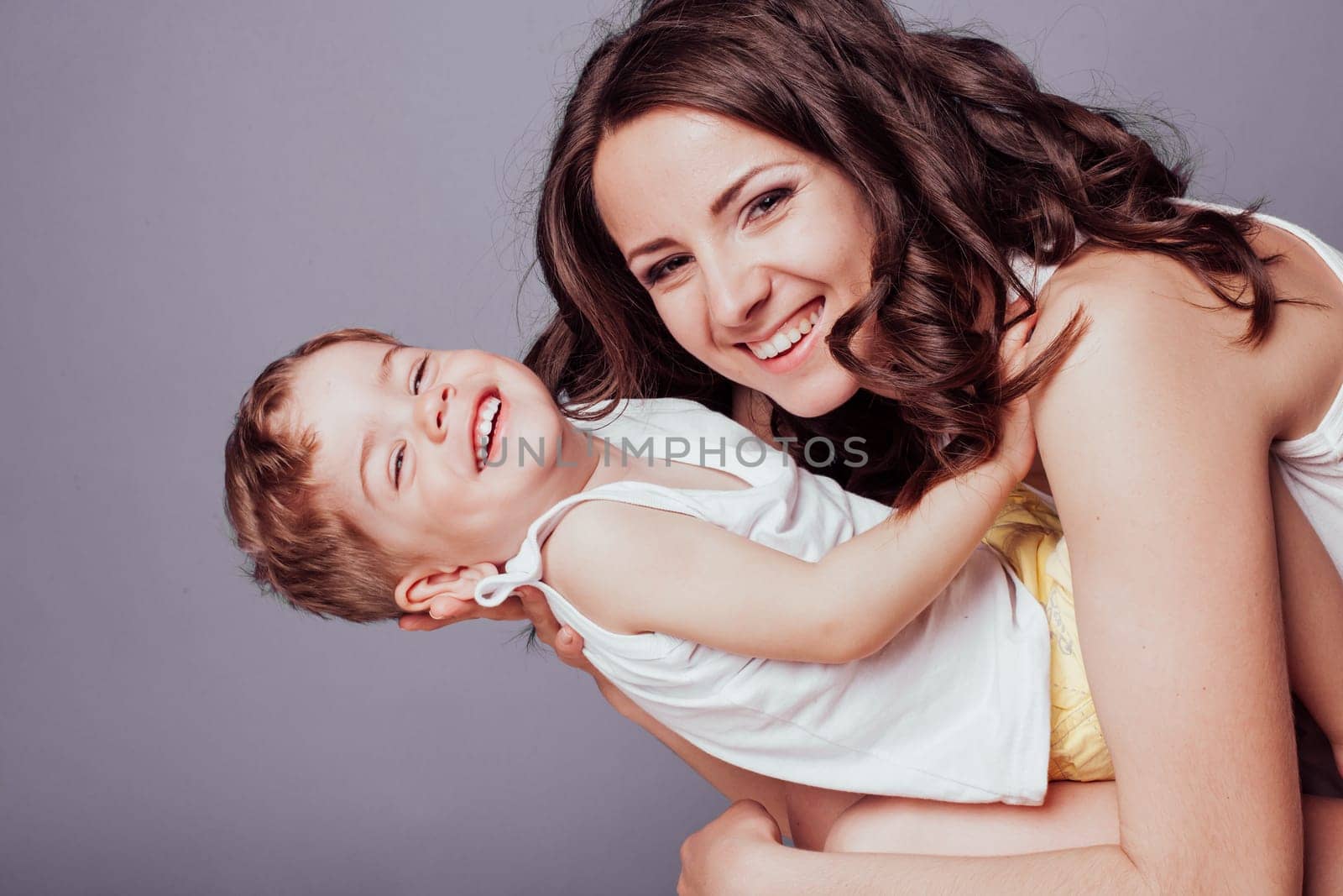 mom playing with young son laughing joy by Simakov