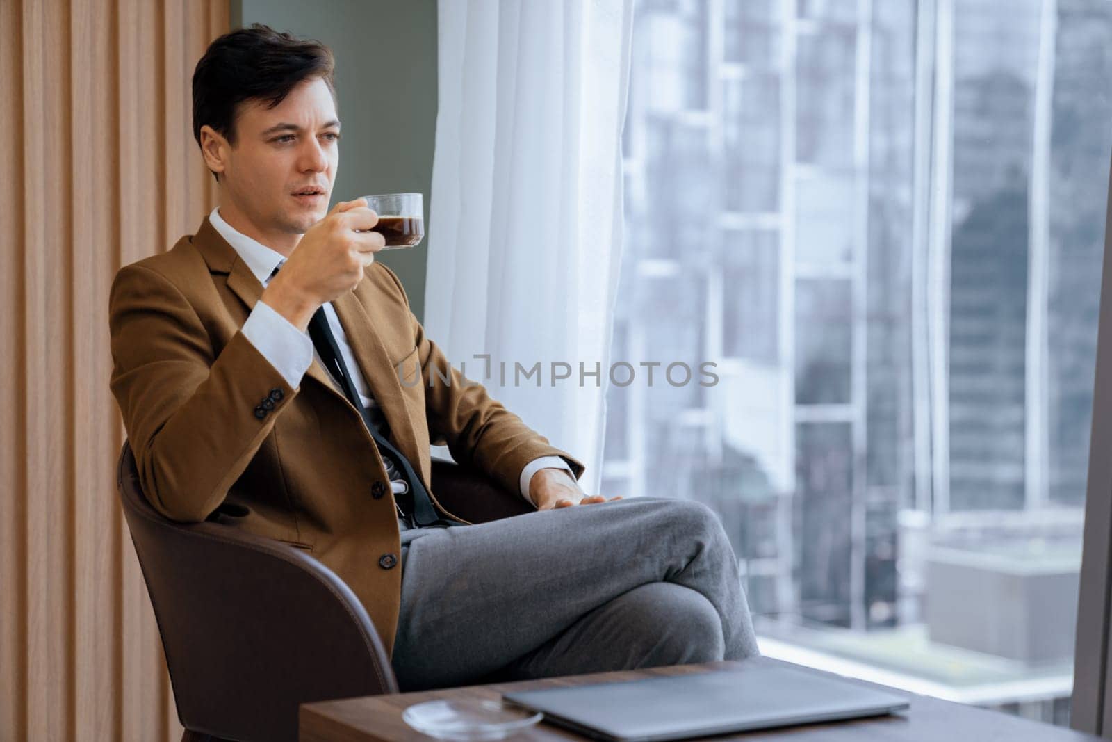 Smart businessman holding coffee cup while looking skyscraper view. Ornamented. by biancoblue
