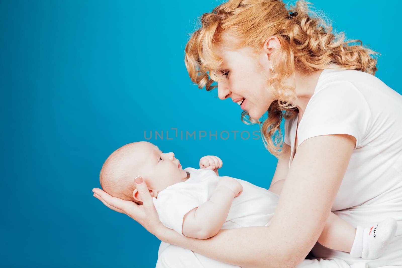 mom looks lovingly at baby son family by Simakov