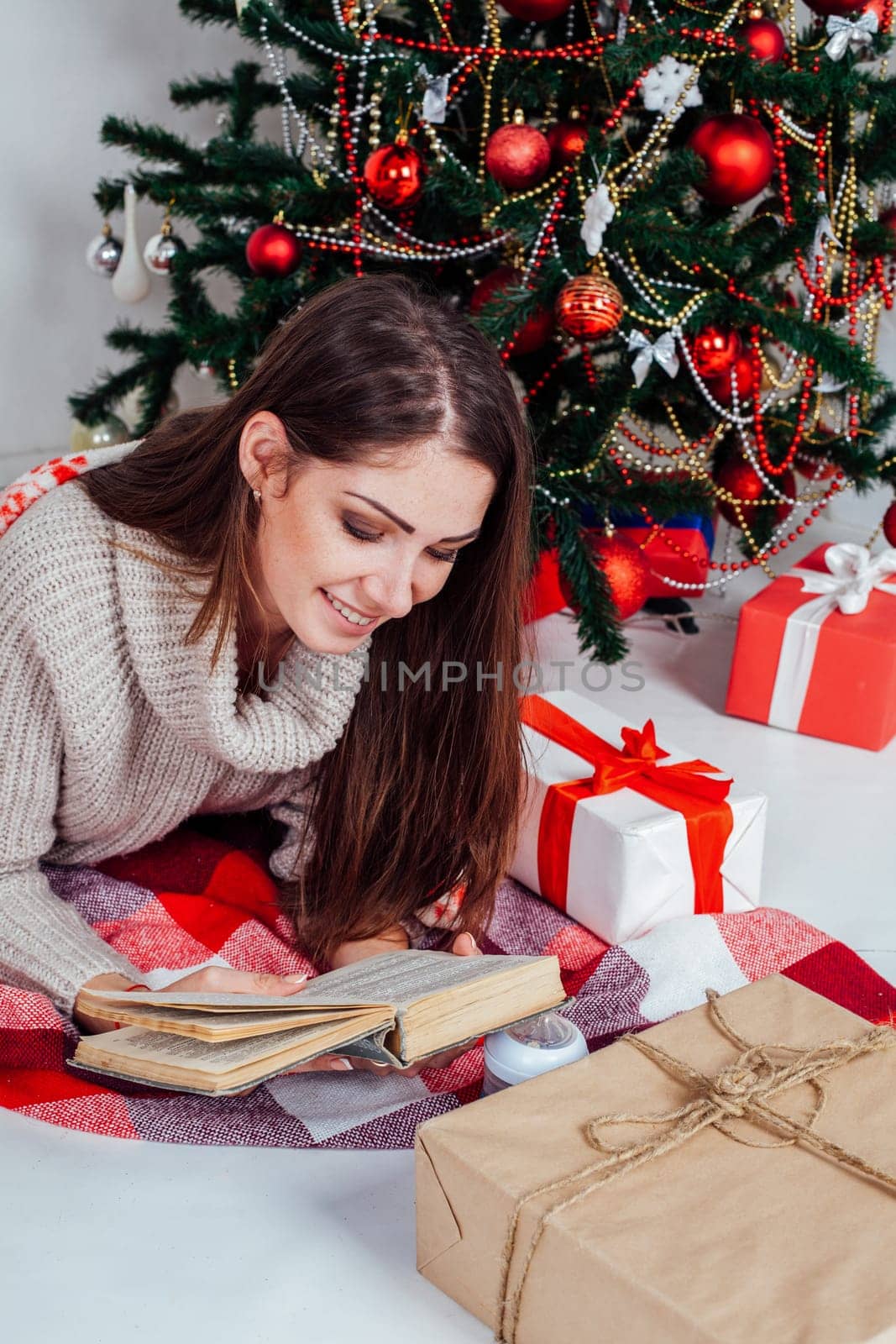 girl reading a book near the Christmas tree Christmas gifts 1