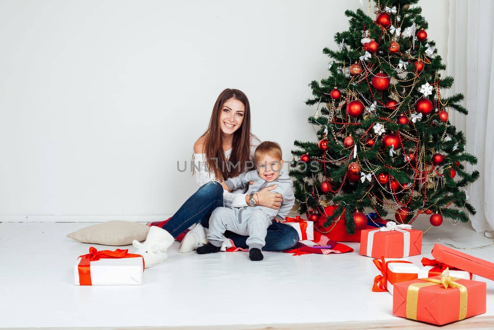 mother and son open gifts on Christmas and new year by Simakov