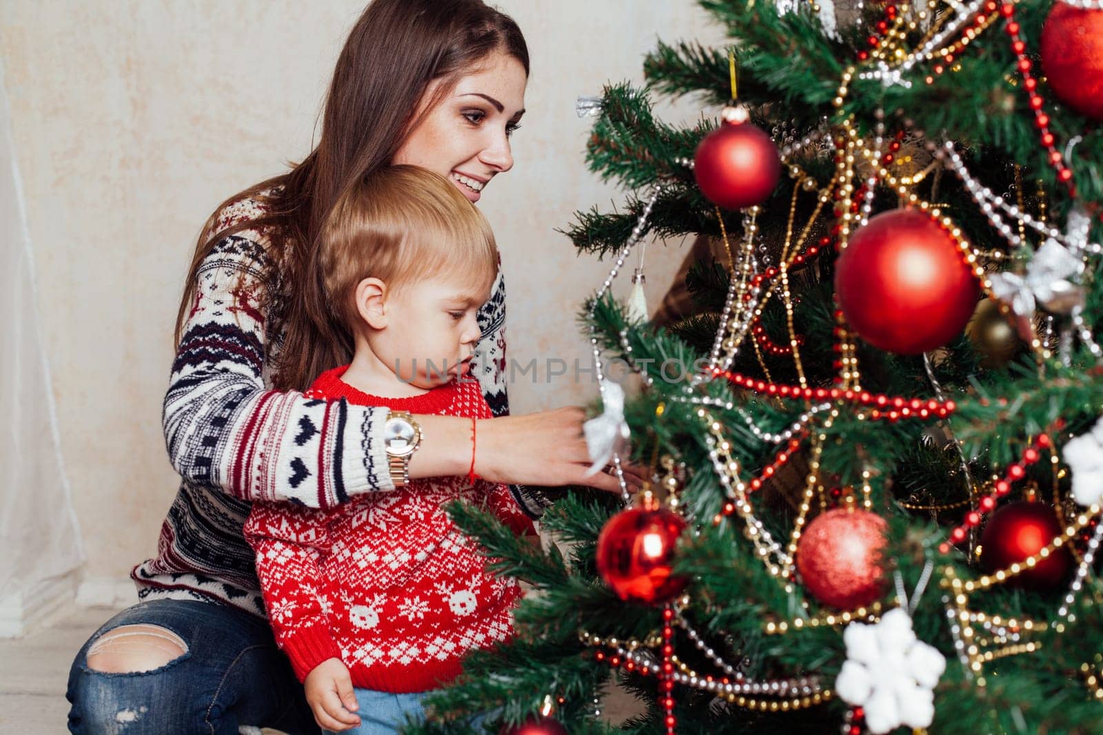 mom with son decorate tree on new year's Gifts Christmas by Simakov