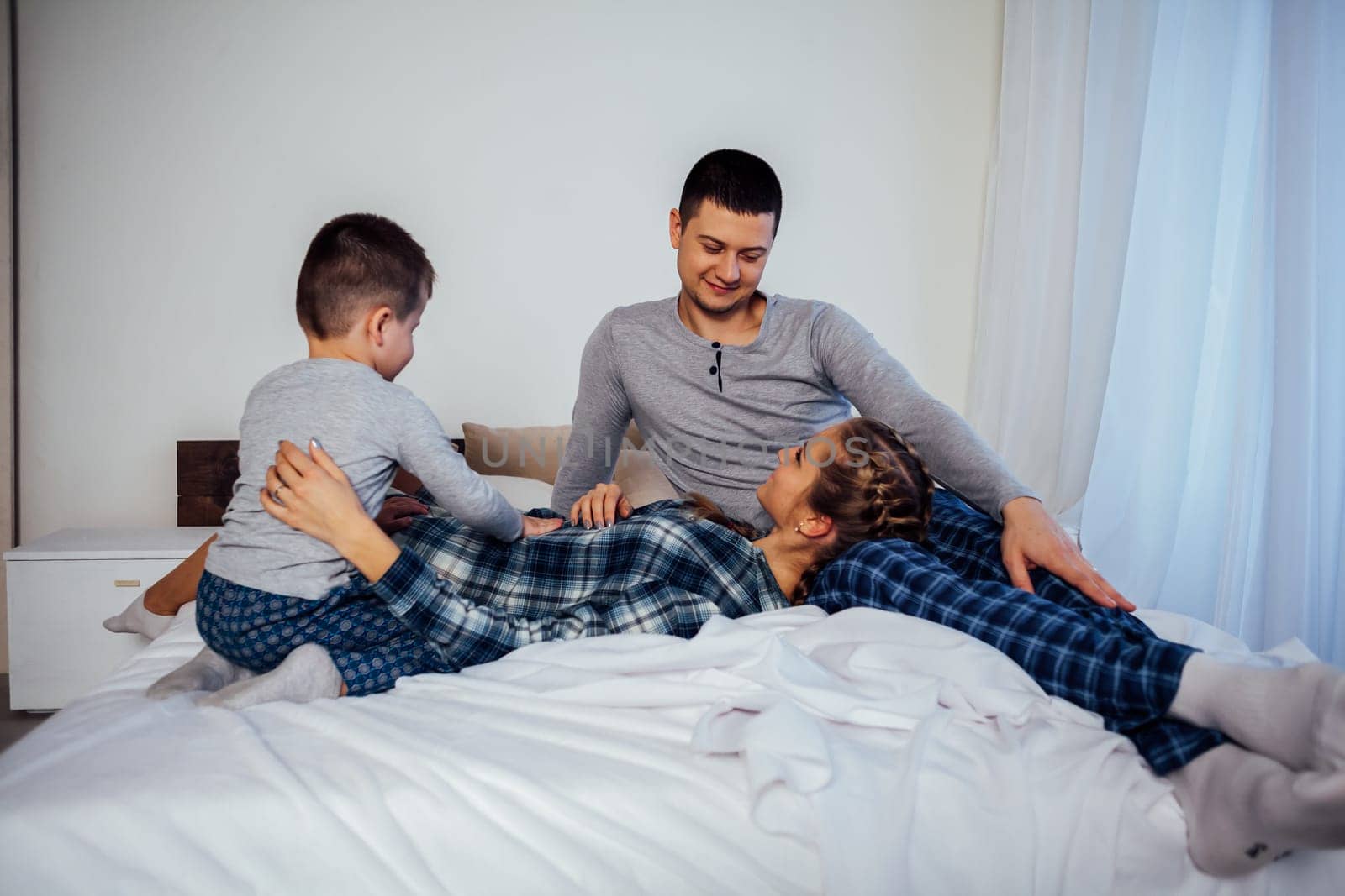 mom dad son in the morning in bed by Simakov