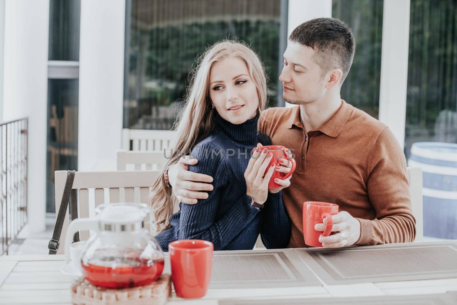 restaurant on the street. a guy with a girl drink hot coffee and tea