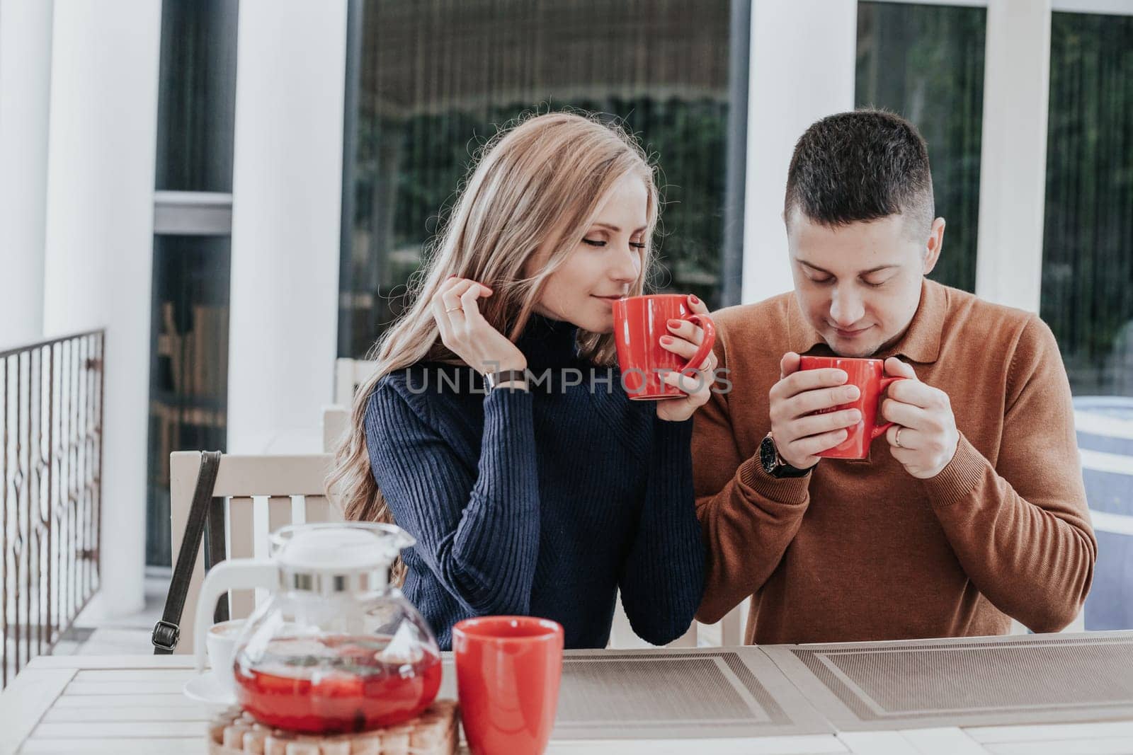 husband and wife on holiday drink hot chocolate coffee tea by Simakov