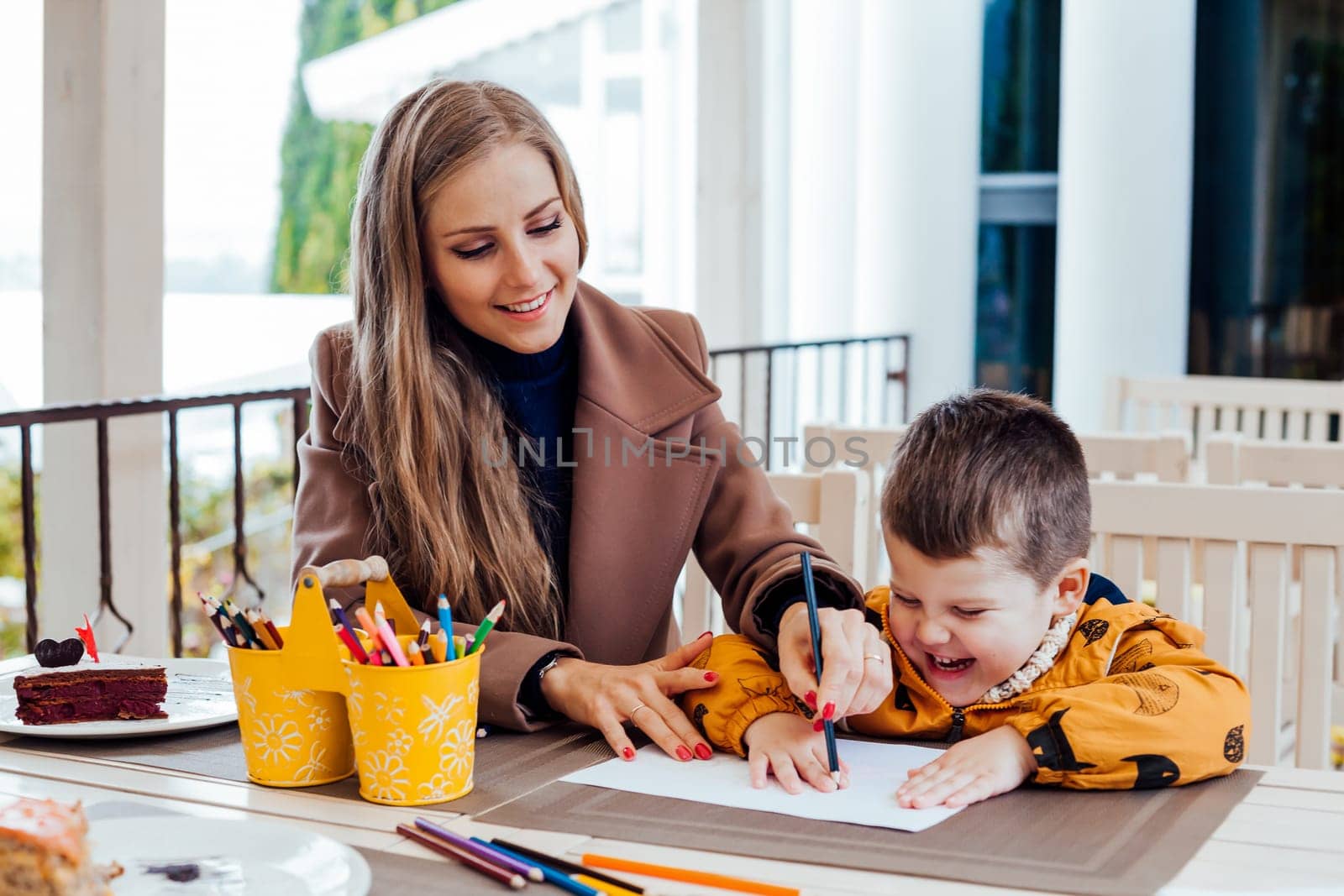 mom helps son to draw drawing colored pencils by Simakov