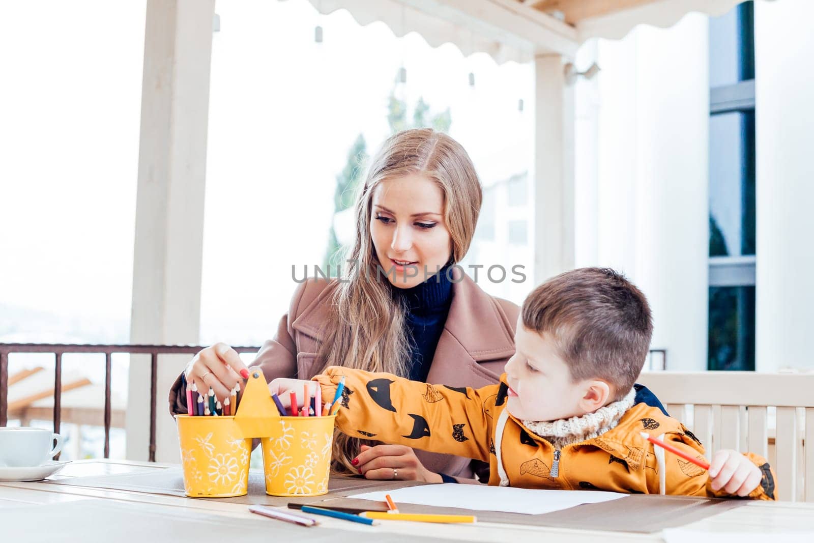 mother and son in the restaurant painted pencils before eating