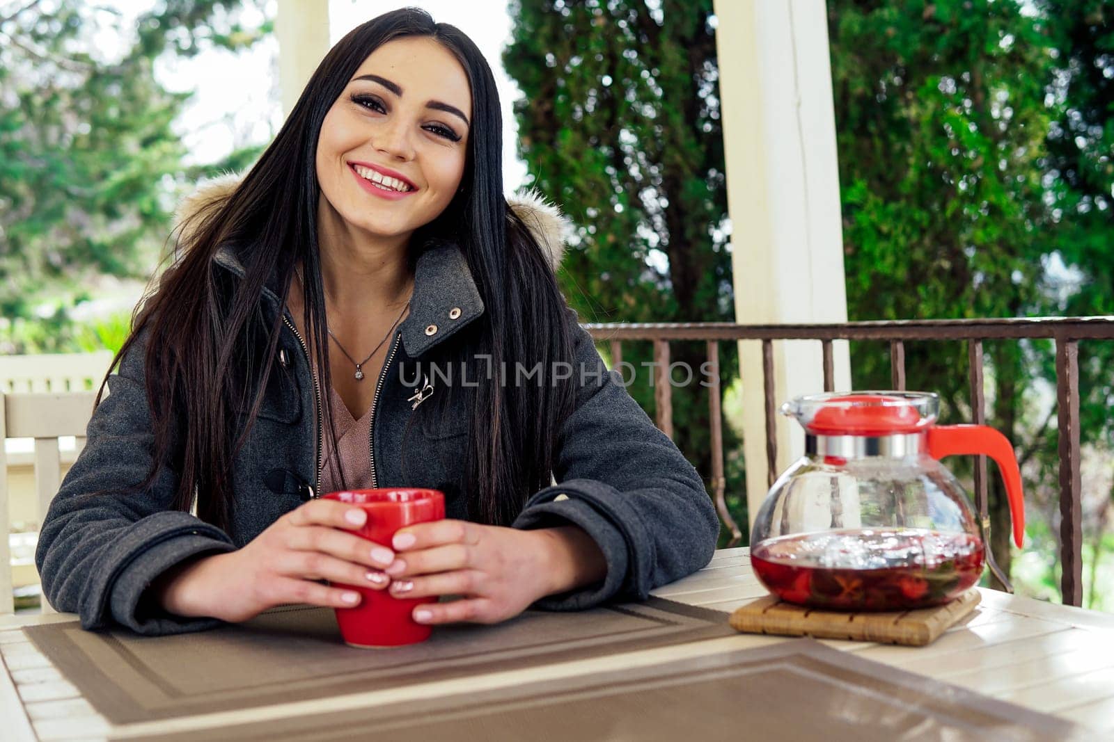 girl drinking a hot drink in the outdoor restaurant by Simakov