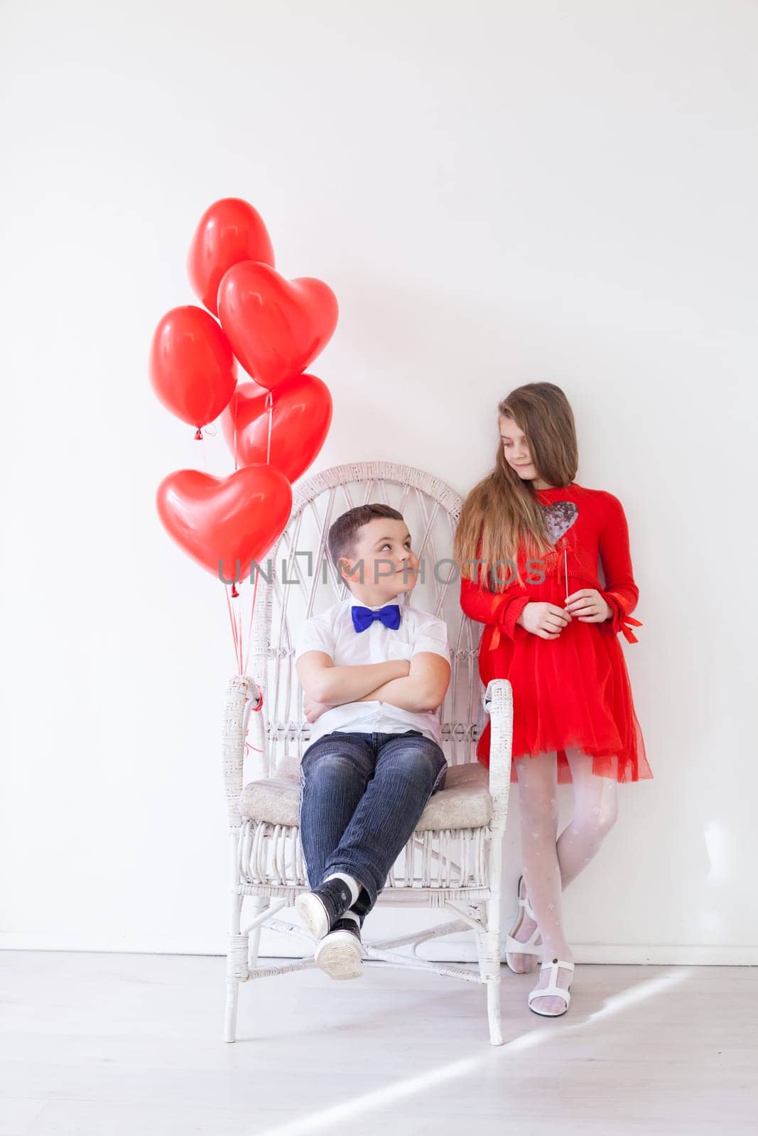 Boy and girl friends with red balloons on Valentine's Day holiday by Simakov