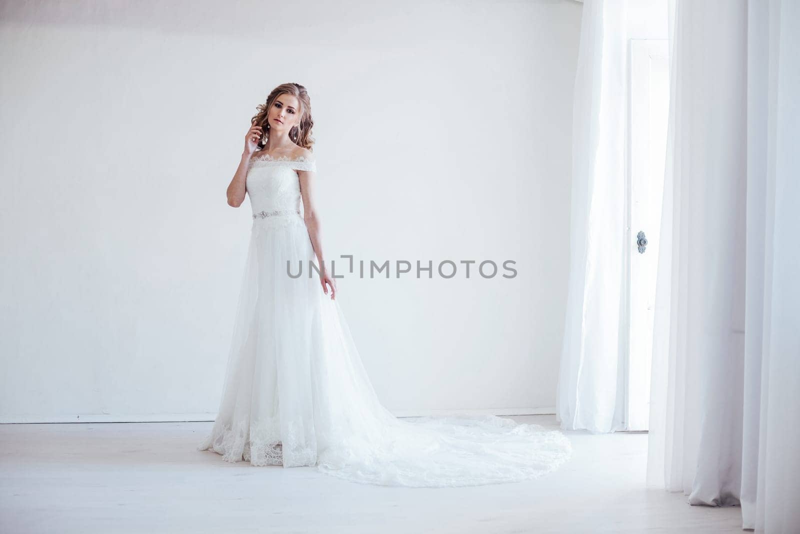 bride in wedding dress in a white room by Simakov
