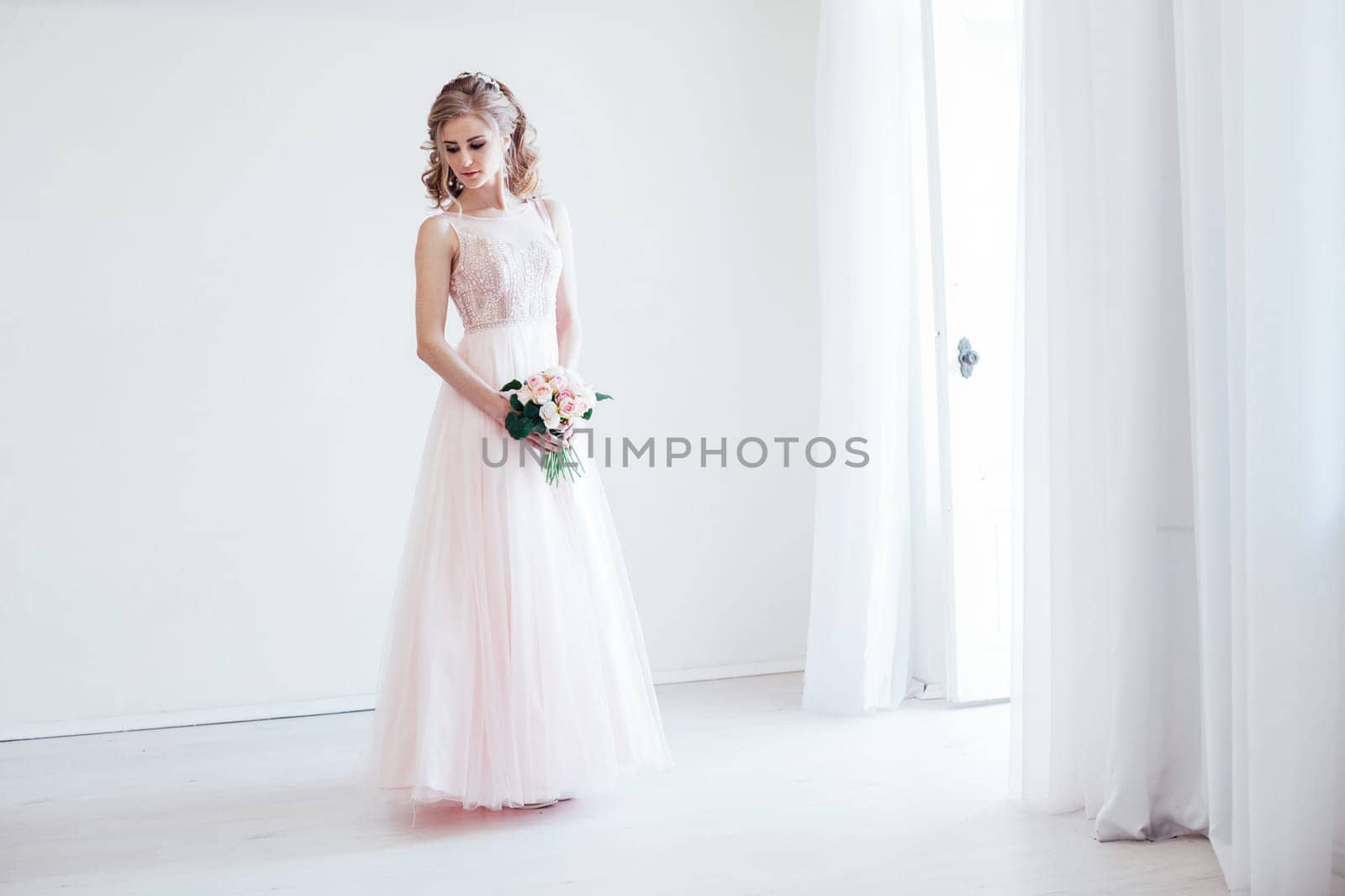bride in a pink wedding dress and bouquet of flowers by Simakov