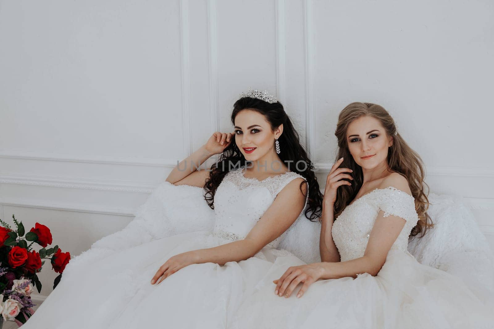Portrait of two young women in wedding dresses in White Hall by Simakov