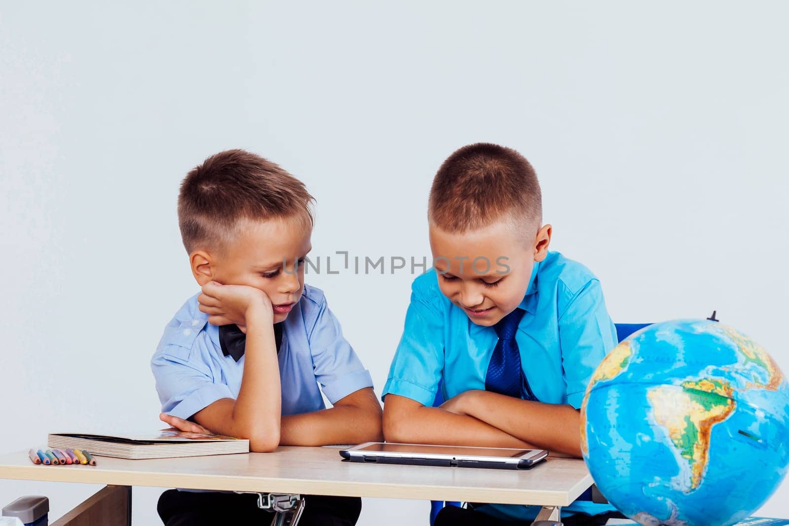 the two boys are looking at Internet Tablet school 1