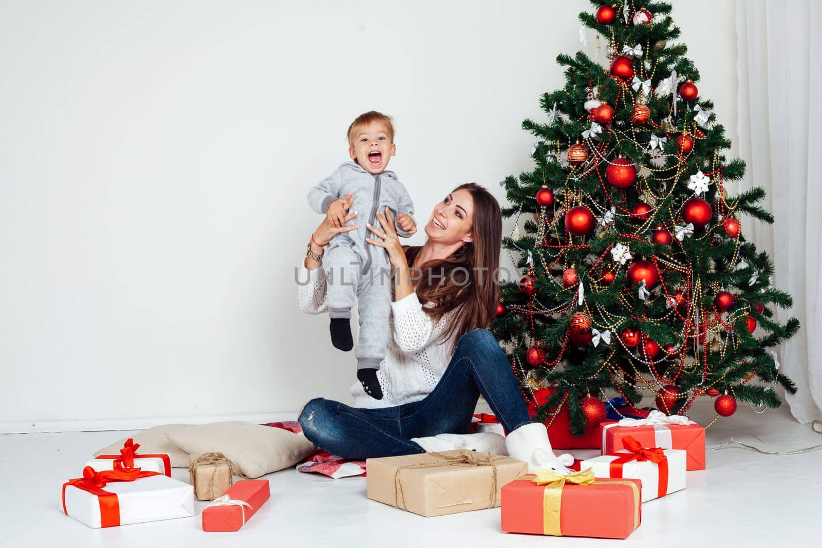 mother and son open gifts on Christmas and new year by Simakov