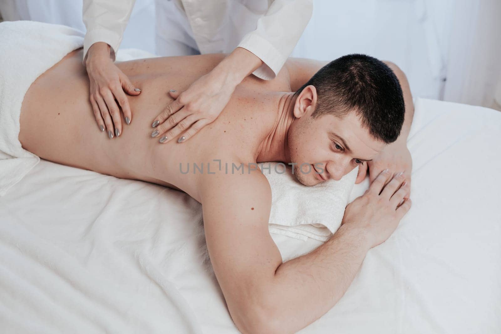 male masseur makes therapeutic massage in the Spa 1