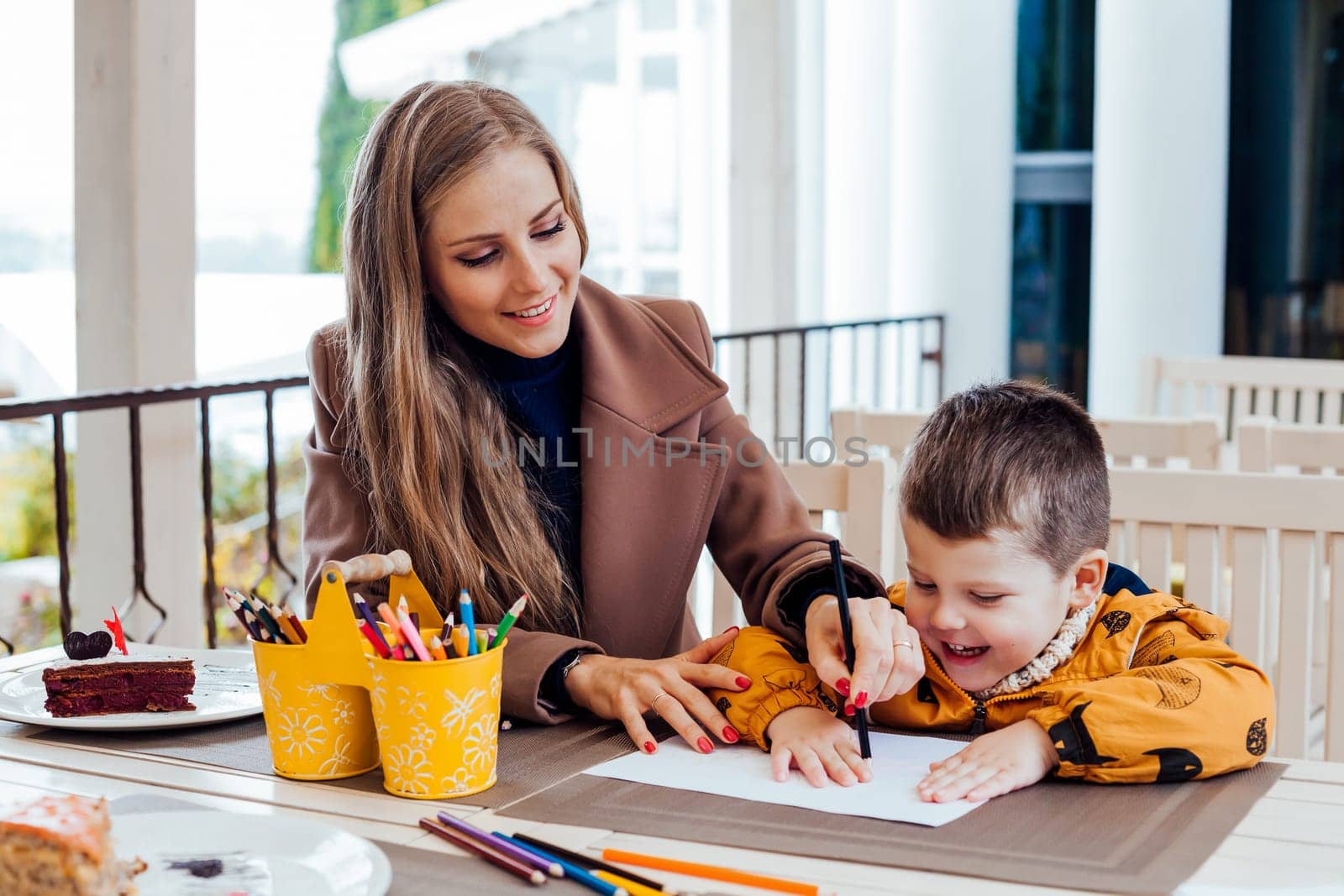 mom helps son to draw drawing colored pencils by Simakov