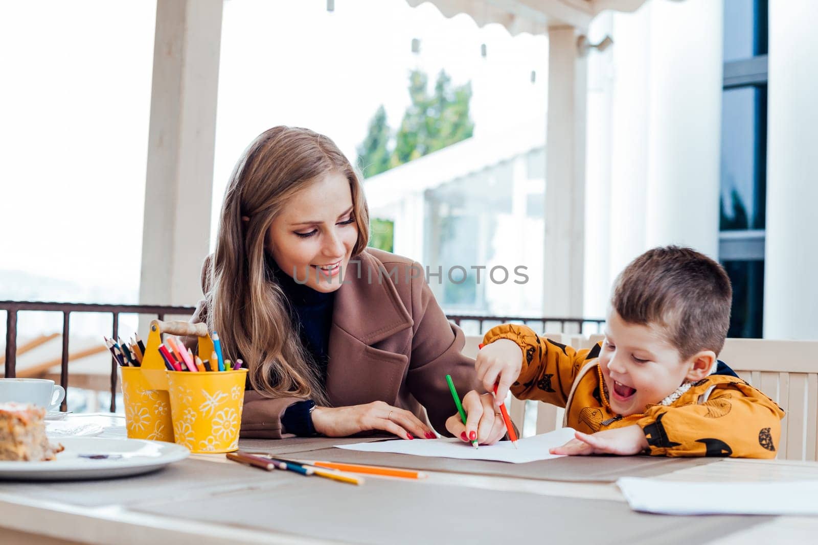 mother and son in the restaurant painted pencils before eating by Simakov
