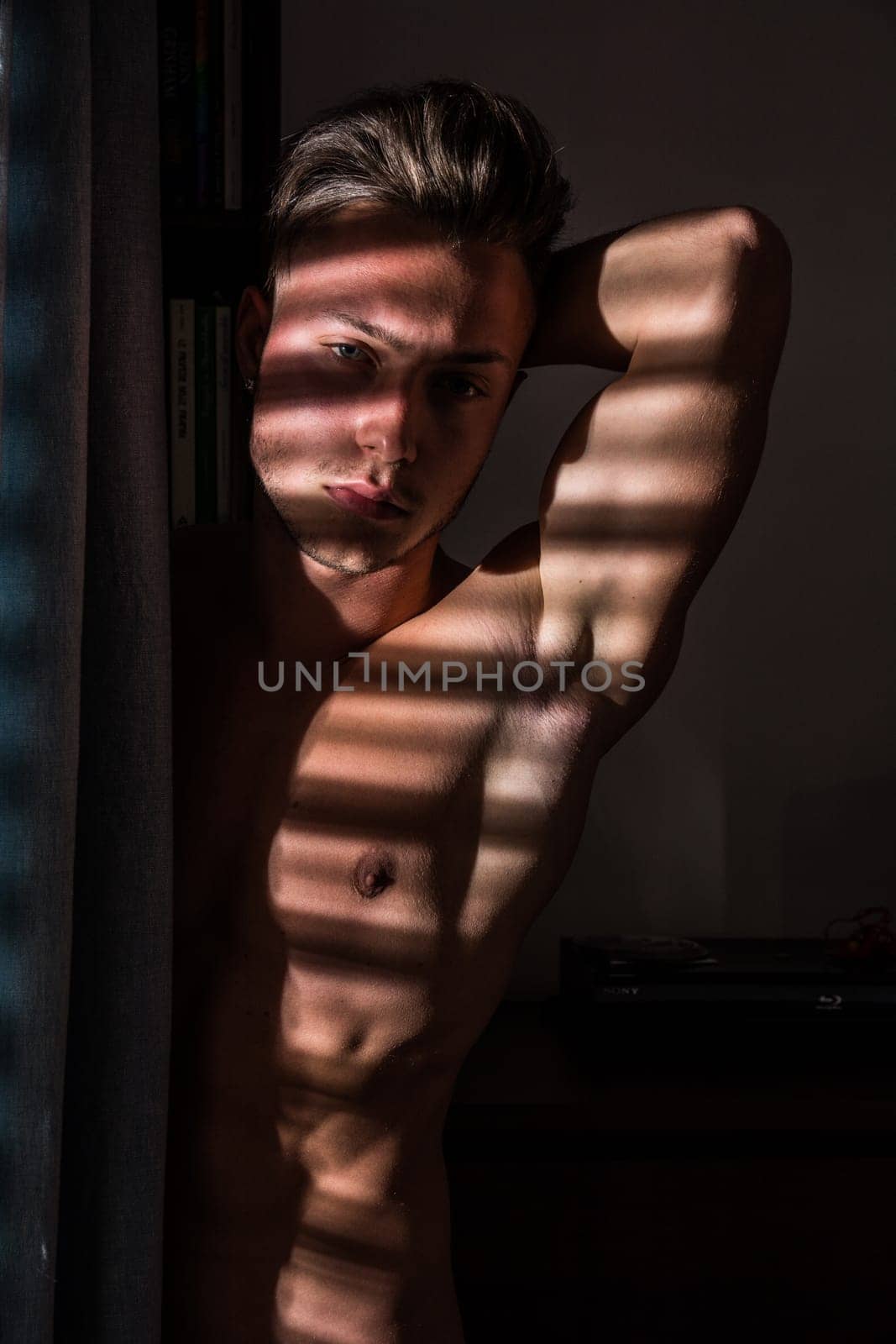 Photo of a shirtless man standing in front of a window by artofphoto