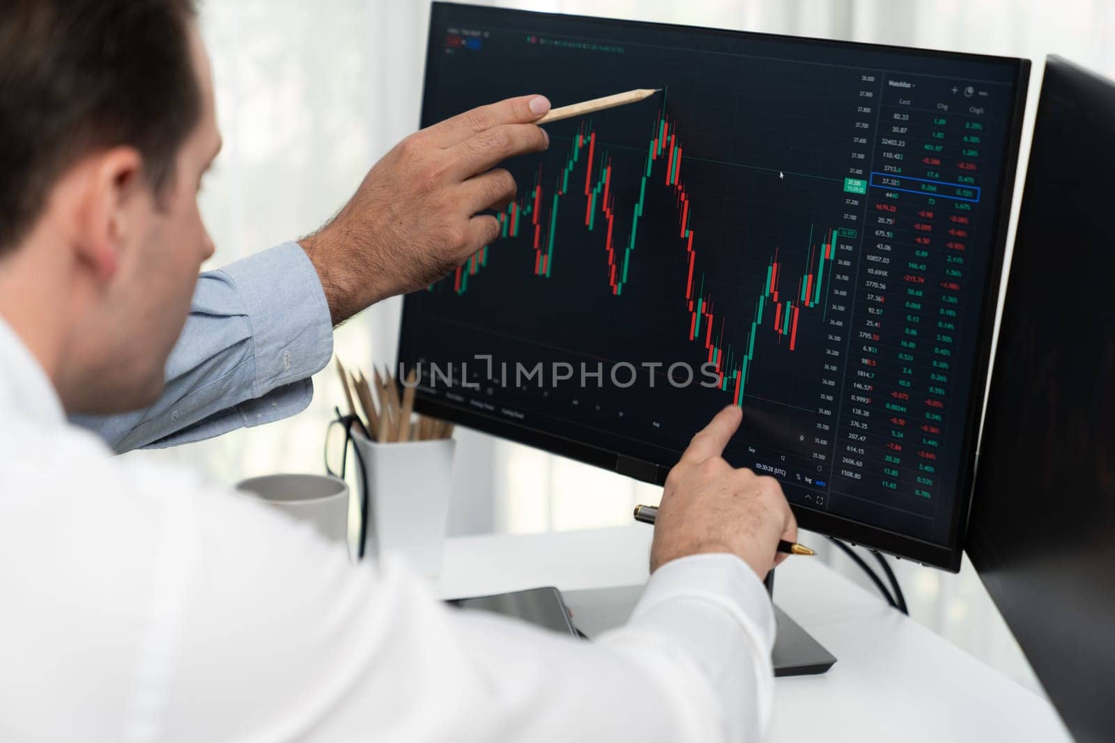 Stock trader pointing highest stock market to present coworker on dynamic valued analysis research on real time monitor screen, cooperating business investment in financial company exchange. Sellable.